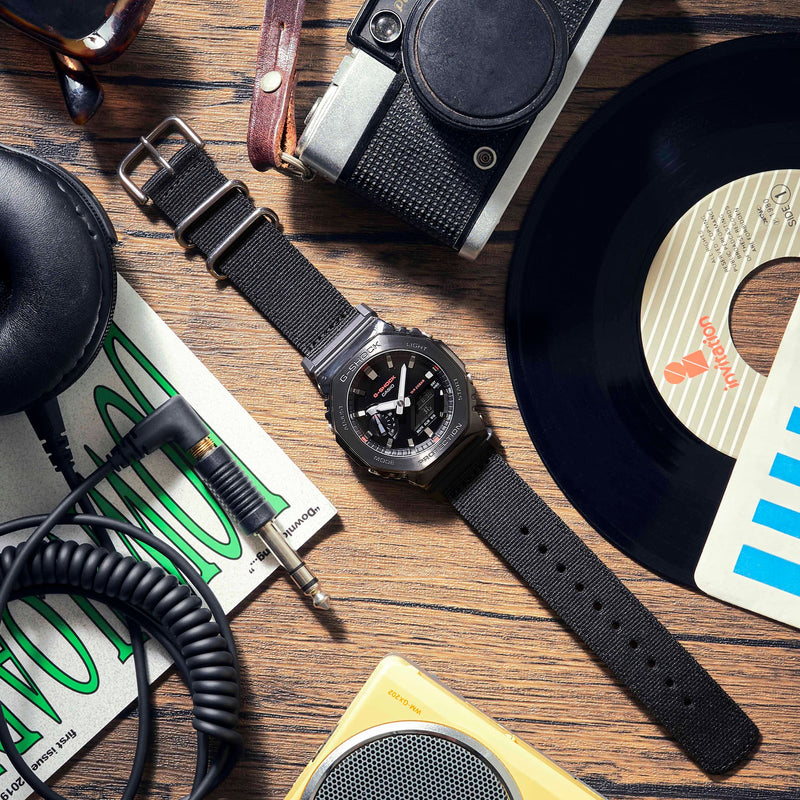 Black analog wristwatch with a round face and dark strap.