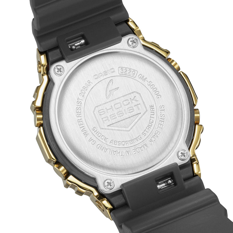 Back of a digital wristwatch with a circular metal casing and black rubber strap.