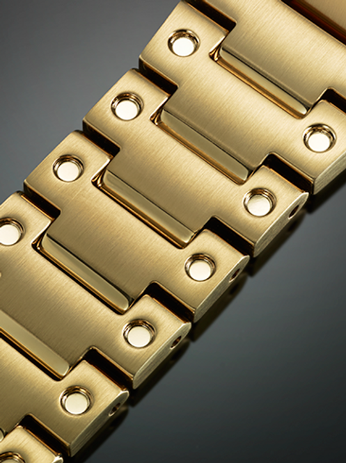 Gold-colored metal watch band or bracelet link with circular holes.