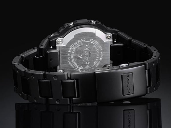 Black metal wristwatch with visible internal mechanisms on its back.