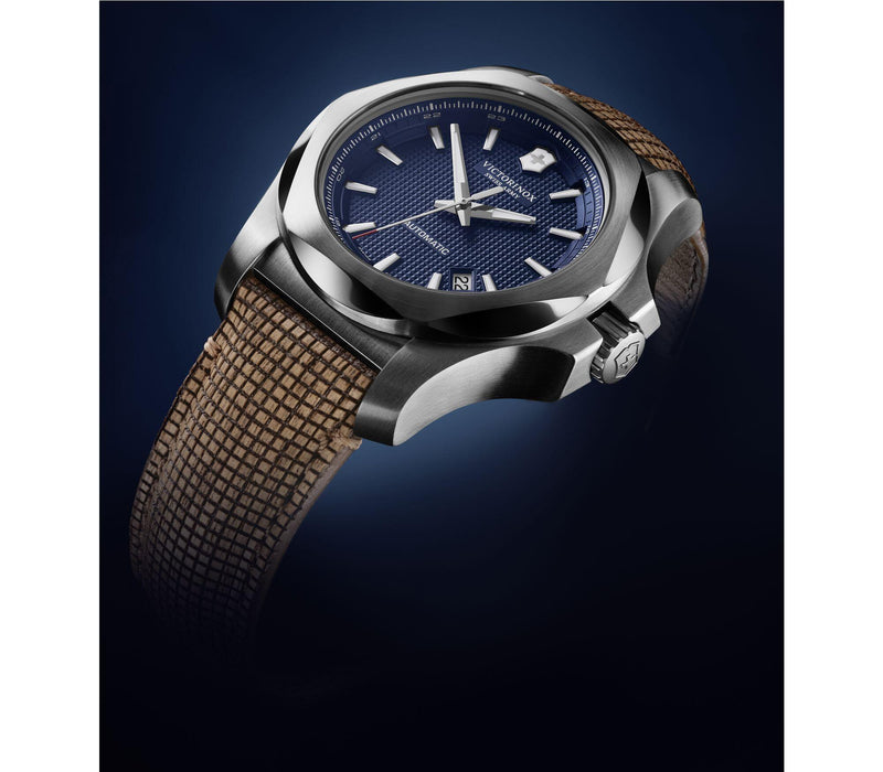 Luxury wristwatch with a blue dial and brown textile strap.