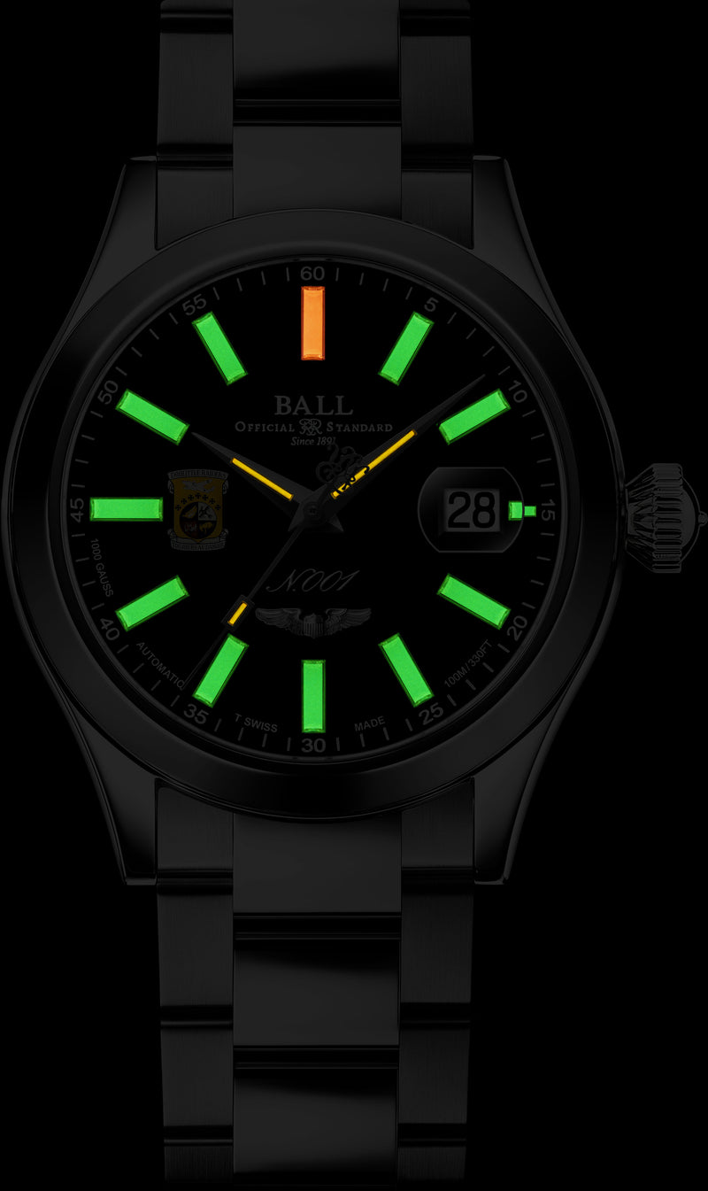 Wristwatch with glowing green hour markers and an orange minute hand.