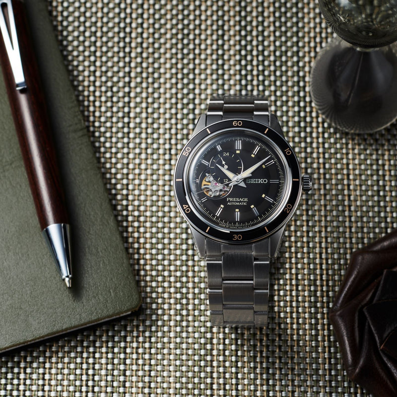 Sleek black Seiko wristwatch with a metal bracelet and visible mechanical components on the dial.