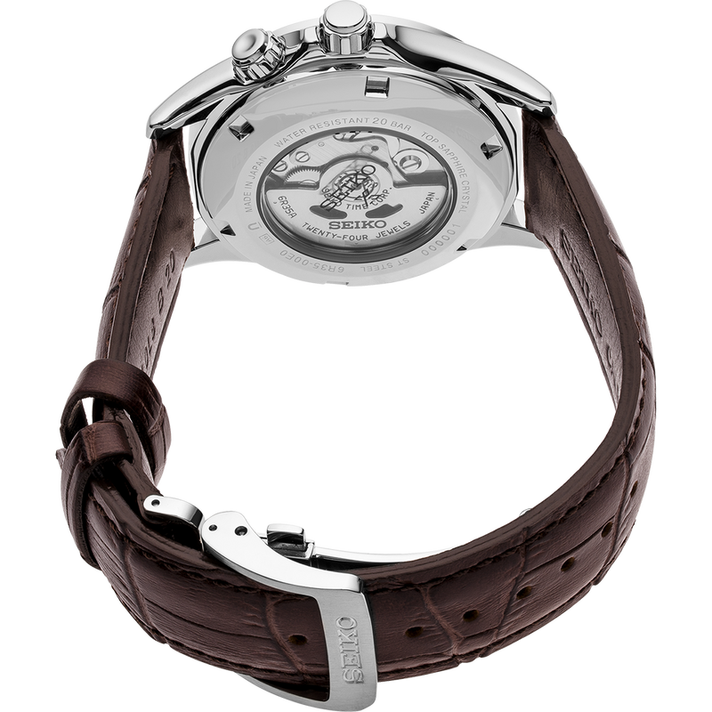 Luxury wristwatch with a brown leather strap and visible mechanical movement through the transparent case back.