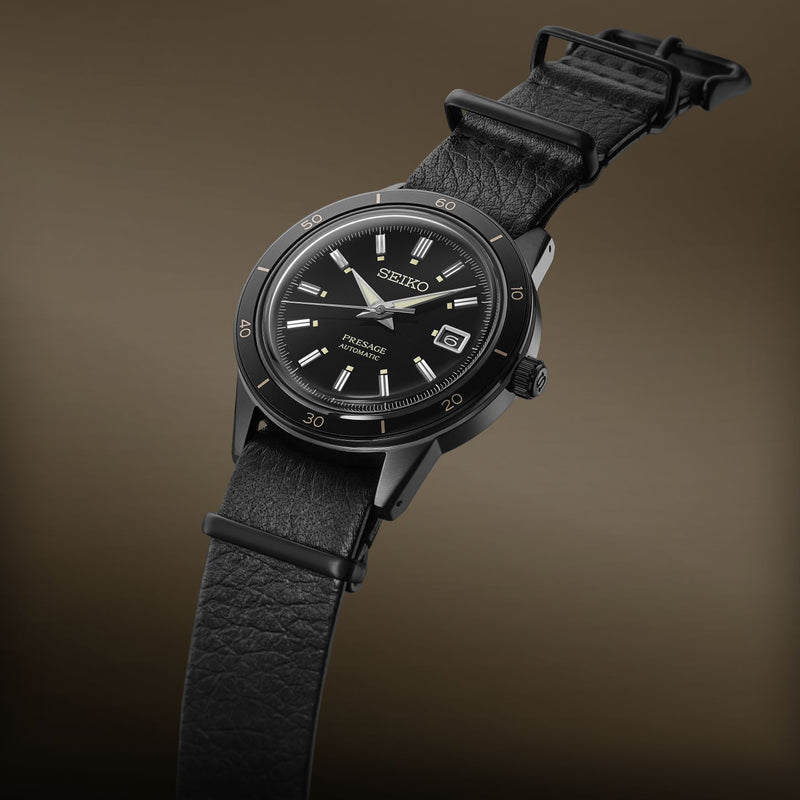 Black wristwatch with a leather strap and round face.