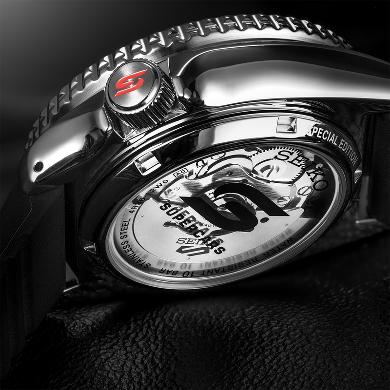 Luxury wristwatch with a visible mechanical movement and red ’S’ logo on the crown.