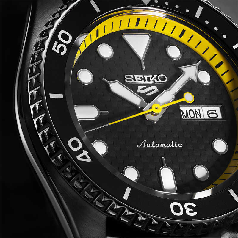 Seiko automatic dive watch with a black face and yellow accents.