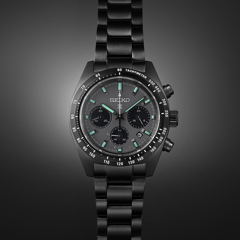 Black Seiko chronograph wristwatch with a metal bracelet and tachymeter bezel.