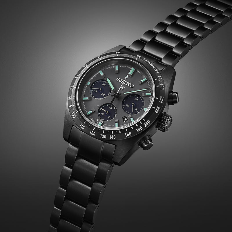 Black metal chronograph wristwatch with a dark dial and luminous markers.