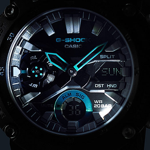 G-Shock watch face with blue illuminated hands and digital displays.