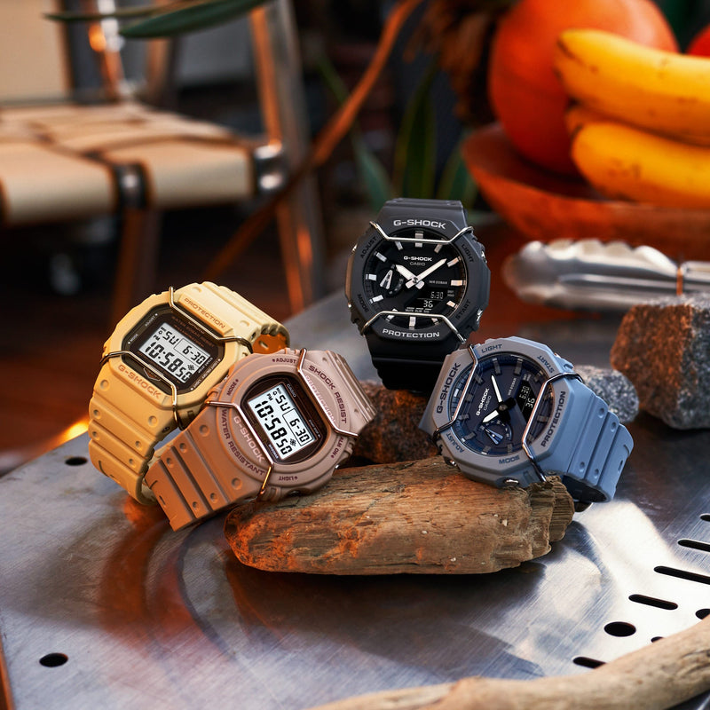 Collection of colorful digital wristwatches displayed on a rock.