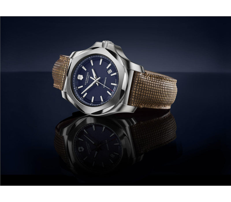 Luxury wristwatch with a blue dial and tan fabric strap.