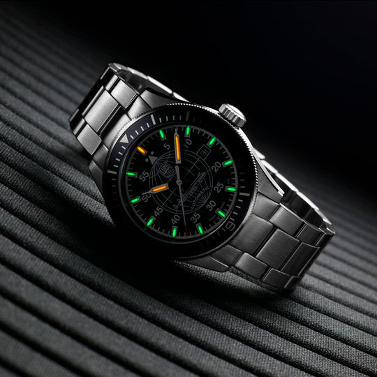 Sleek black wristwatch with luminous green and orange markings on its face.