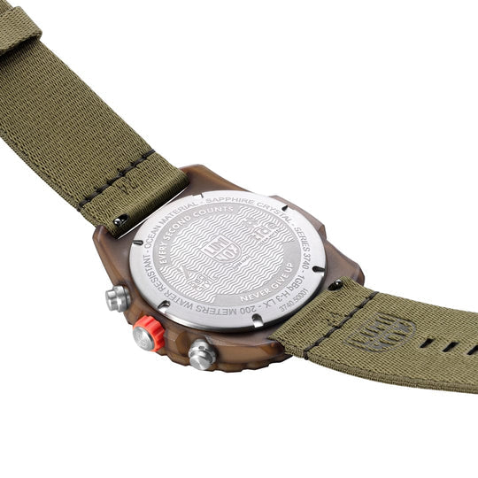 Wristwatch with a green fabric strap and brown casing.