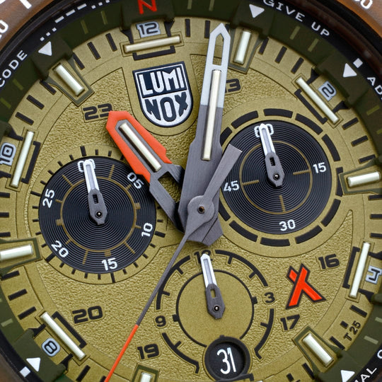 Close-up view of a Luminox watch face with multiple dials and a gold-toned background.