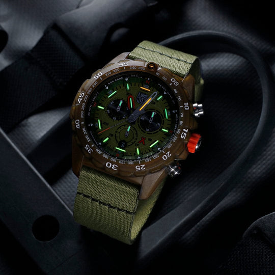 Military-style chronograph watch with a green canvas strap and luminous dial markings.