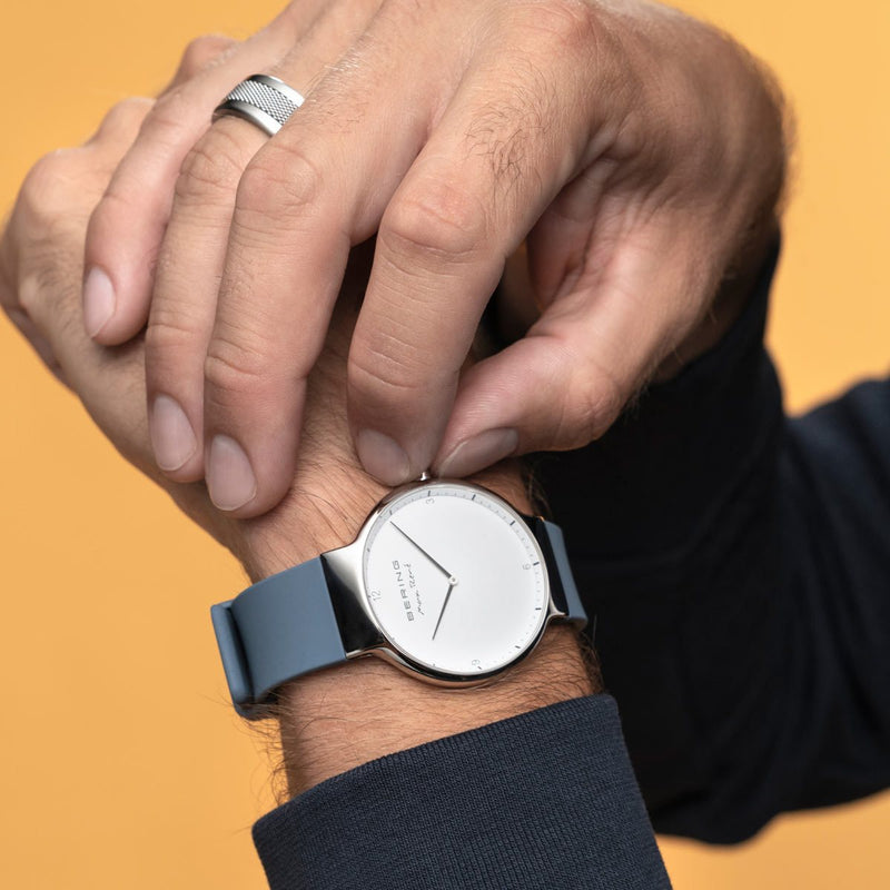 Wristwatch with a minimalist white face and gray leather strap.