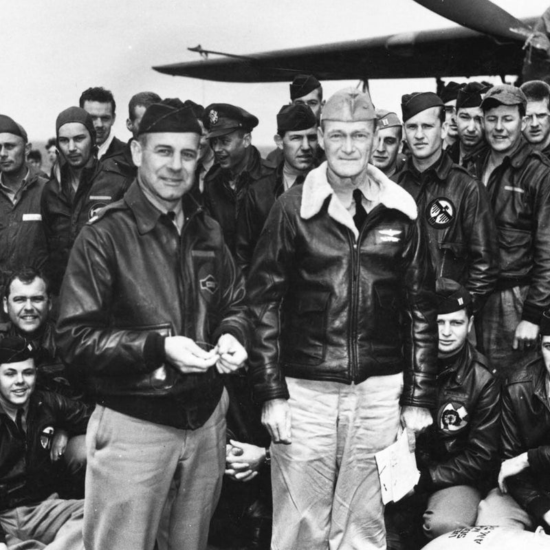 Group of military personnel, likely pilots or aircrew, posing together in front of an aircraft.