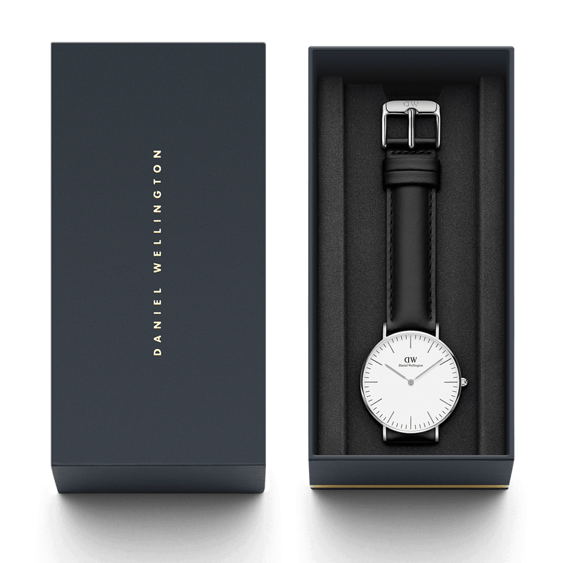 Wristwatch with a white face and black leather strap in a presentation box.