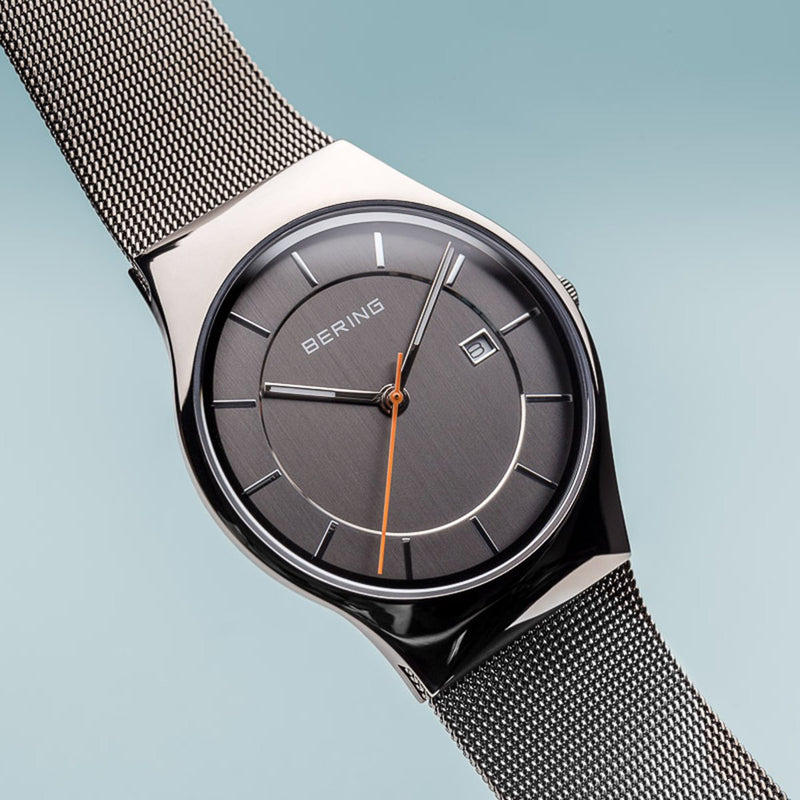 Sleek wristwatch with a gray dial and mesh metal band.