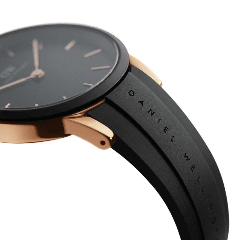 Sleek wristwatch with a black face, rose gold bezel, and black leather strap.