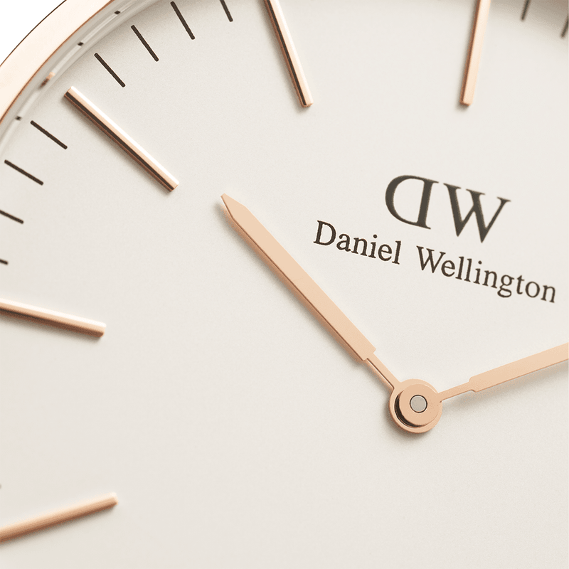 Close-up of a Daniel Wellington watch face with gold-colored hands and hour markers.