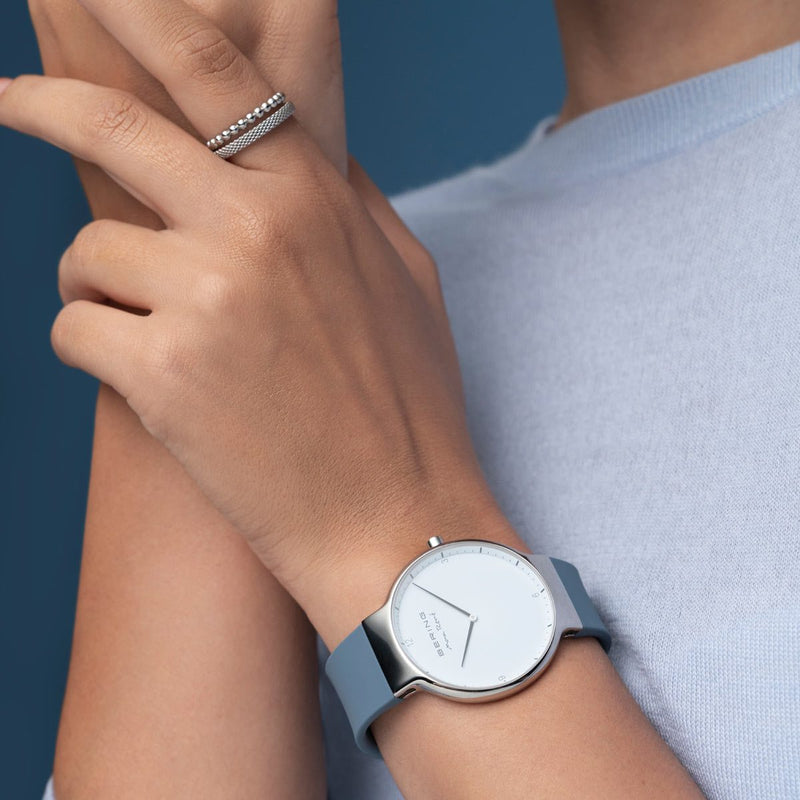 Wristwatch with a light blue band and minimalist white face.